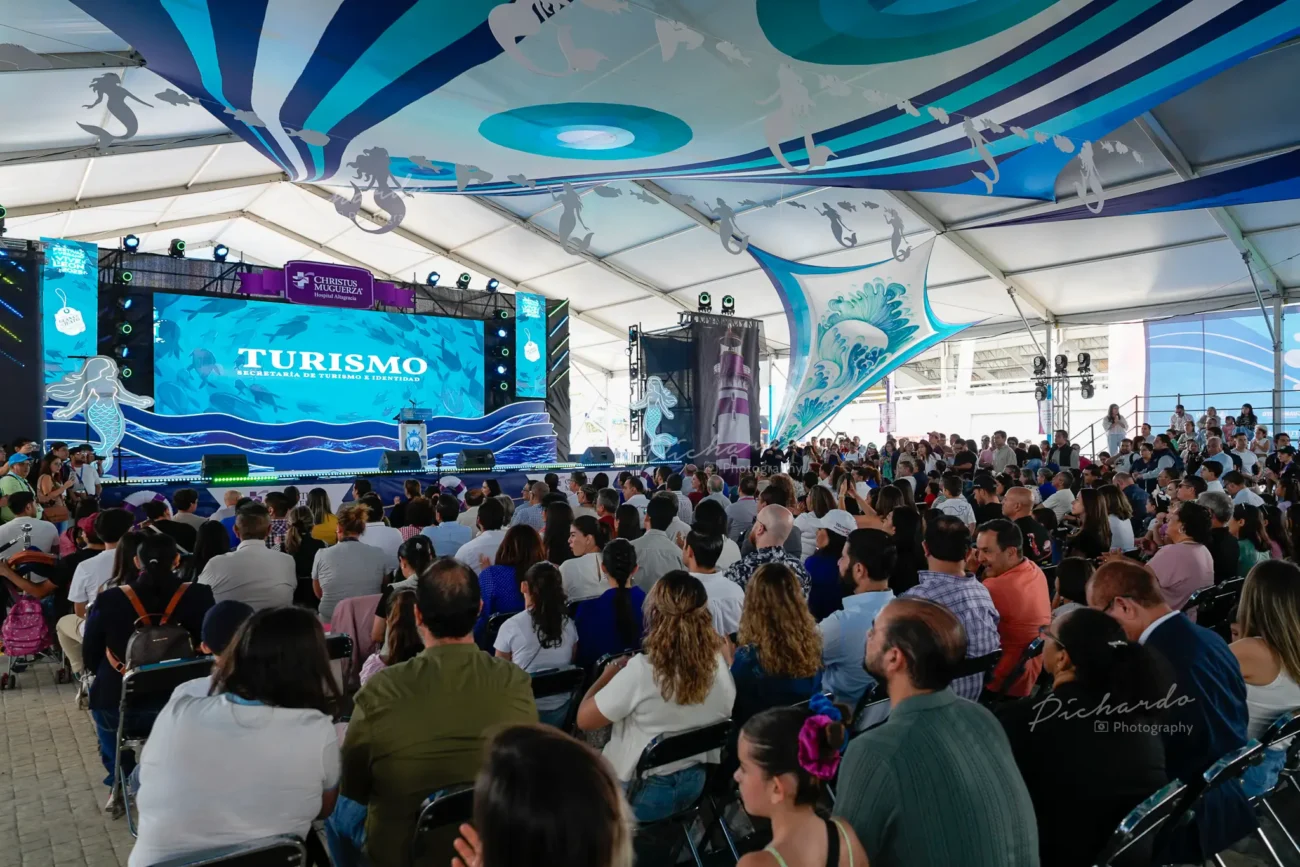 Amplia vista del público atento durante la presentación del Festival de Verano Vive León 2025 en León Guanajuato. Gran asistencia bajo toldo decorado con temática marina.