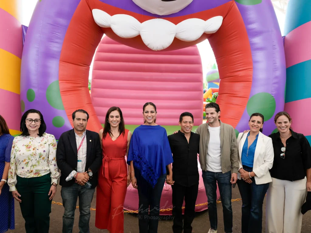 Autoridades posando frente a inflable gigante en el Festival de Verano León 2025