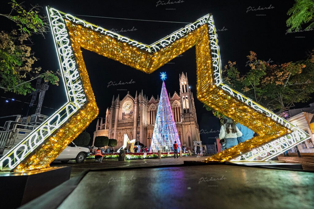 Vista del Templo Expiatorio y el árbol de navidad LED a través de una estrella gigante dorada iluminada en León Guanajuato.