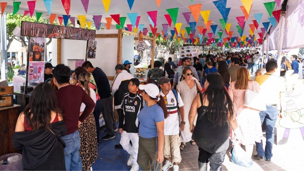 Multitud de personas paseando y comprando en los pasillos llenos de puestos de helados durante la Feria de la Nieve en León, Guanajuato.