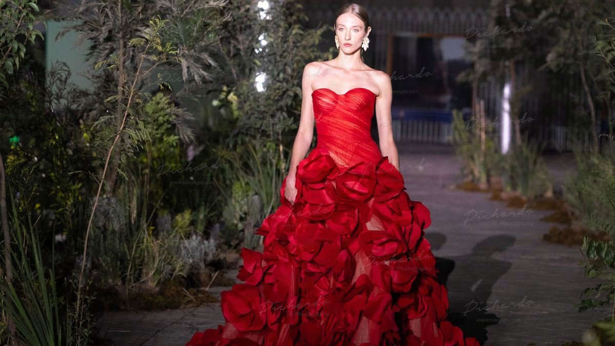 Modelo vistiendo un espectacular vestido rojo con volumen y diseño de rosas 3D creado por Iann Dey durante la Pasarela de SAPICA.