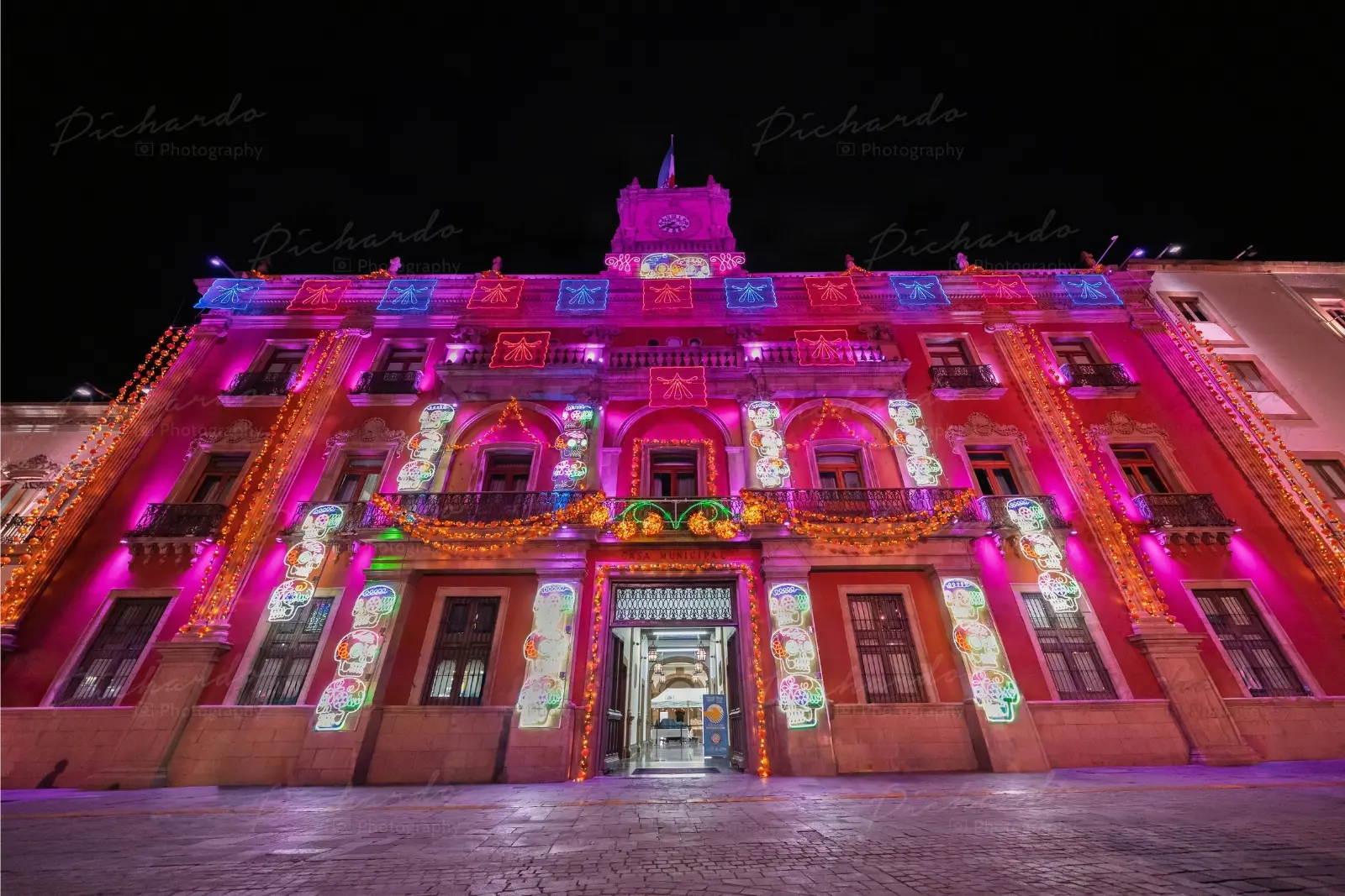 Presidencia Municipal de León iluminada de noche con motivos de Día de Muertos durante el Festival 2026